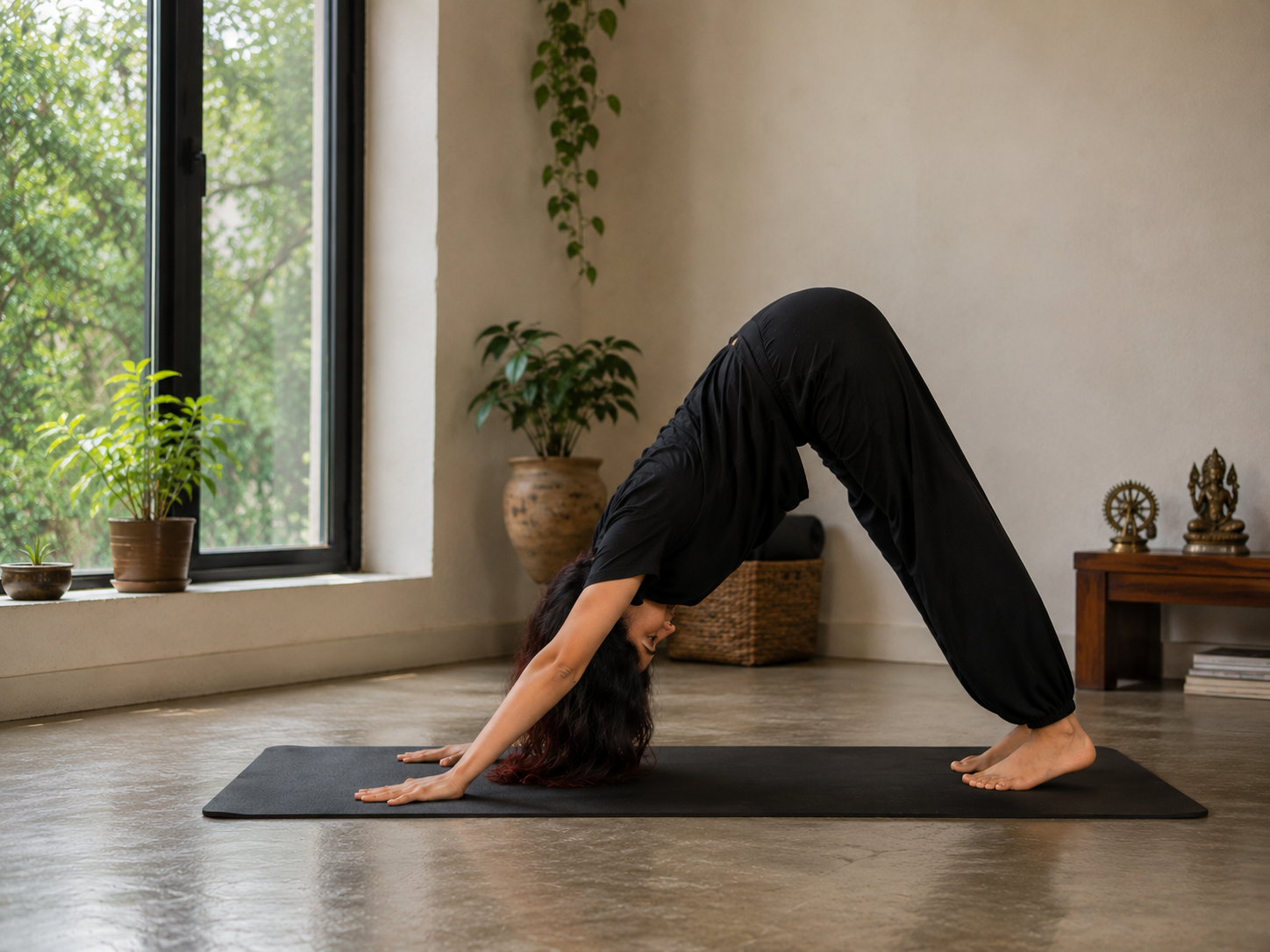 Shuchita resting in downward-facing dog on a yoga mat, showing a gentle reset pose used in small morning online yoga sessions.